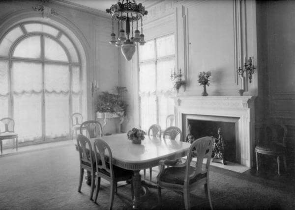 Photo of Guggenheim Mansion's dining room with windows that fill the room with light while French doors provide access to the covered arcade and breakfast room