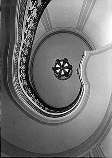 Photo shows the winding staircase of the Guggenheim Mansion looking from the ground floor up to the ceiling